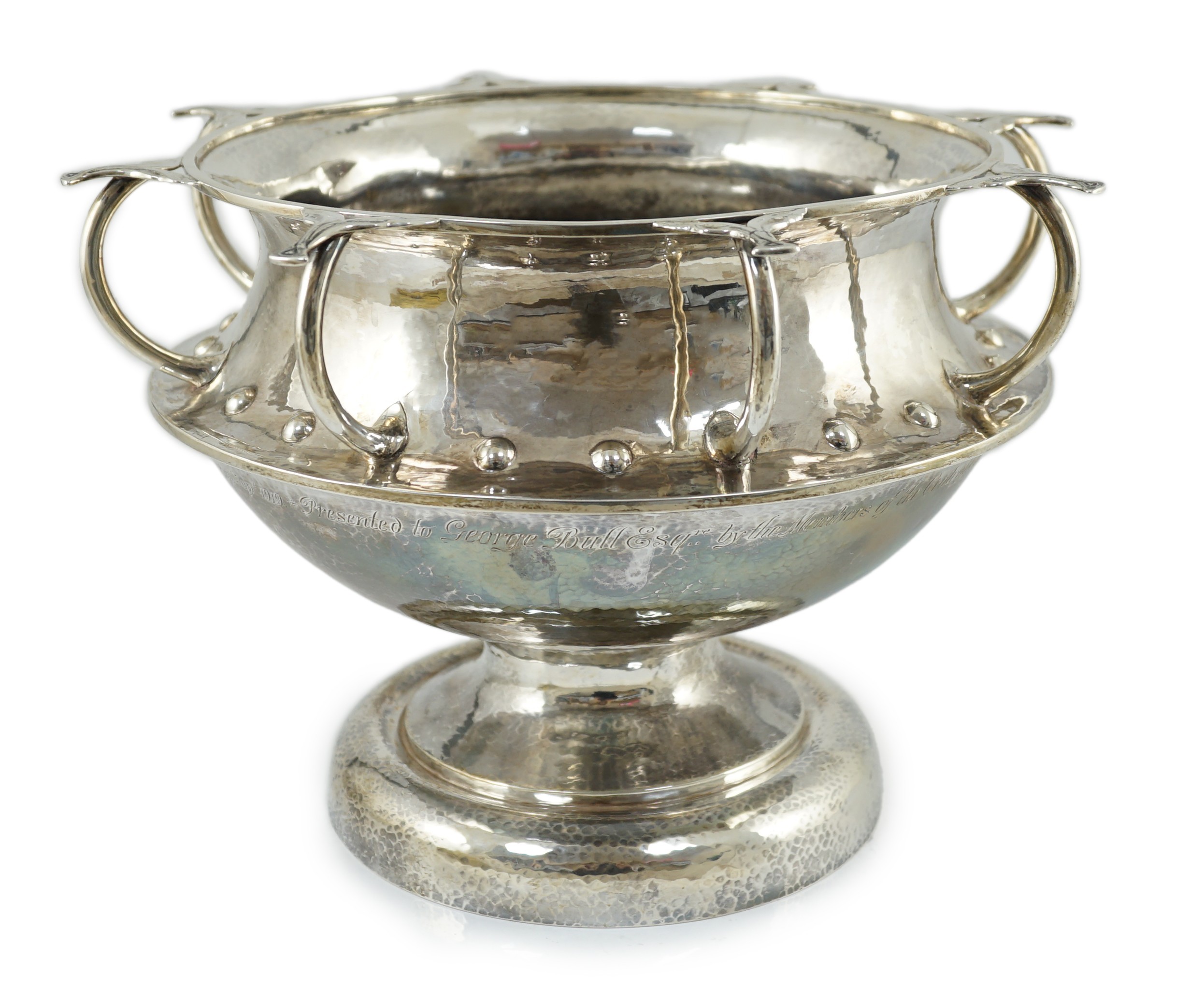 A George V Arts & Crafts planished silver octuple handled pedestal punch bowl, by Albert Edward Jones